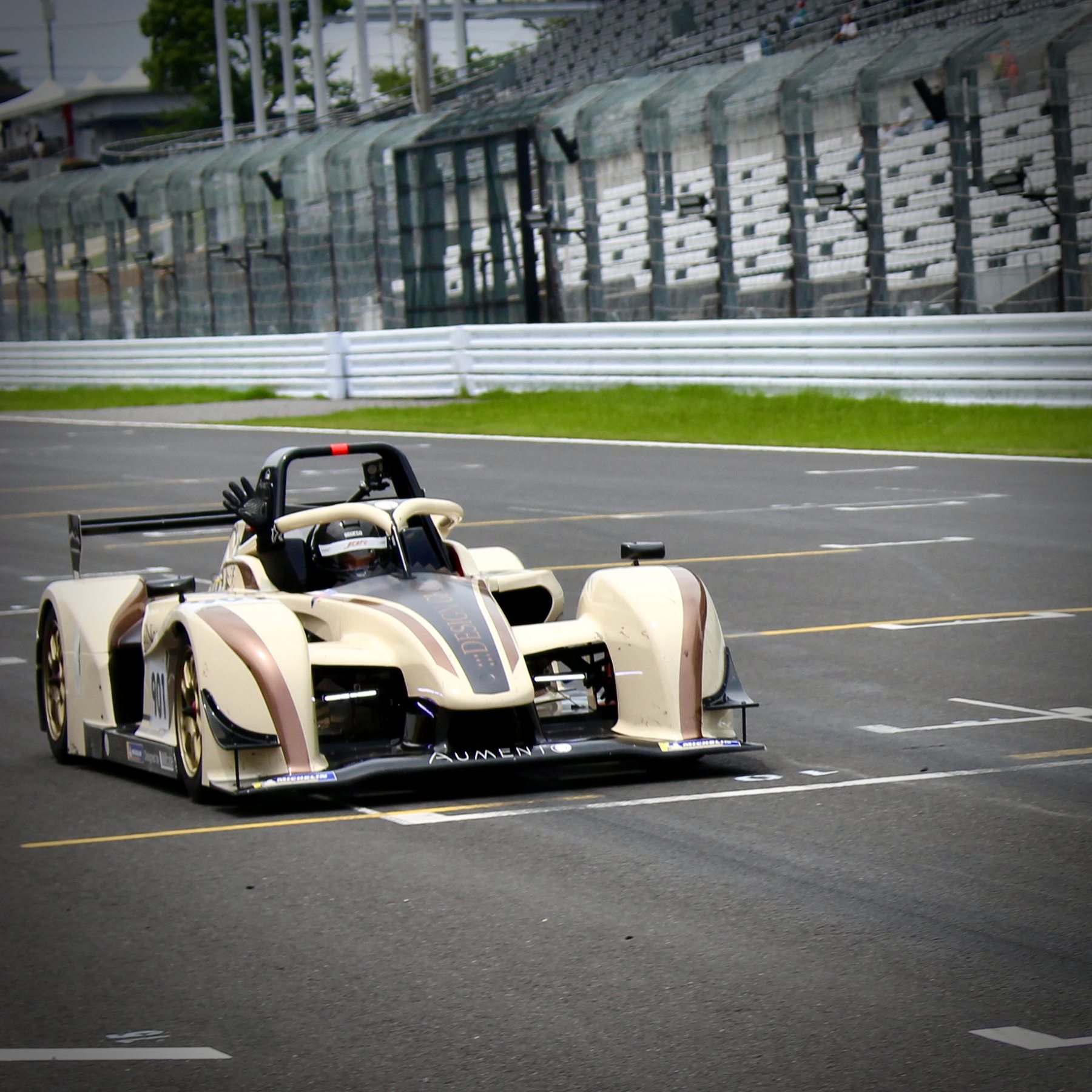 鈴鹿のコースを走行するv.Granz。コクピットからドライバーが手を挙げる